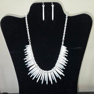 Silver metal bib fringe necklace with matching earrings.